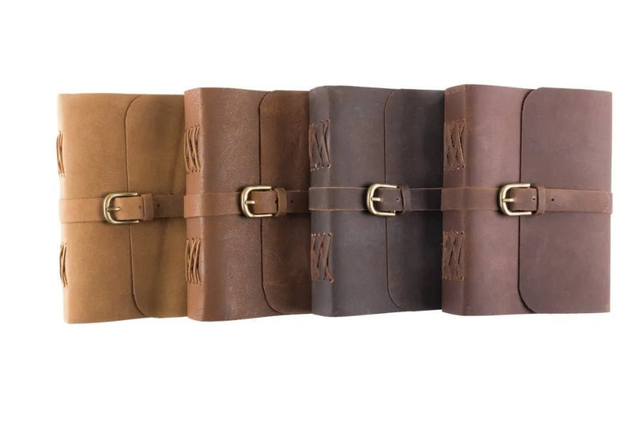 Set of four leather-bound books with buckles on a white background