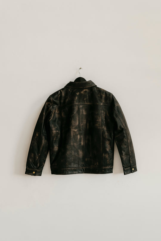 Back view of the Hailwood Distressed Brown Leather Jacket by Indepal from Bolt + Buckle hanging on a white wall.